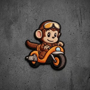 May include: An embroidered patch featuring a brown monkey wearing a brown aviator cap with yellow goggles. The monkey is riding a bright orange motorcycle with a black tire and a light blue headlight. The design has a thick black border.