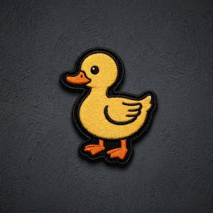 May include: An embroidered patch featuring a yellow duckling with an orange beak and orange webbed feet. The duckling has a black outline and a single black eye, depicted in a side profile view with its wings tucked against its body.