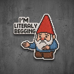 May include: An embroidered patch featuring a pixel art gnome with a red hat, white beard, blue shirt, and brown pants. A speech bubble attached to the left side contains the black text "I'M LITERALY BEGGING" in a blocky, pixelated font style.