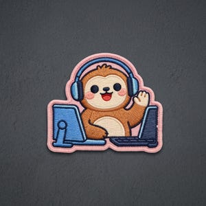 May include: An embroidered patch featuring a brown sloth with pink cheeks wearing blue headphones. The sloth is positioned between a light blue computer monitor and a dark blue laptop, with one hand raised in a wave gesture, outlined in pink.