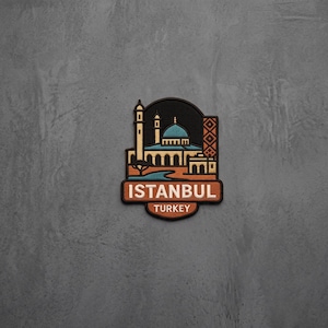 May include: A rectangular embroidered patch featuring a stylized illustration of a mosque with a blue dome and minaret. The design includes a geometric pattern on the right side and the text ISTANBUL TURKEY in white letters on a brown background.
