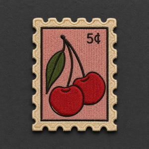 May include: A rectangular embroidered patch shaped like a postage stamp with a scalloped border in cream thread. The center features a light pink background with two red cherries, a green leaf, and the black text 5¢ printed in the top right corner.