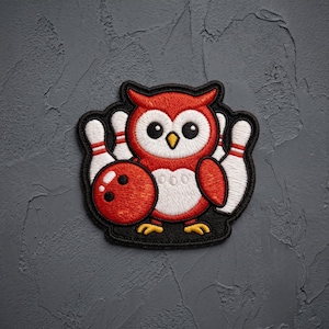 May include: An embroidered patch featuring a red and white owl holding a red bowling ball with three finger holes. The owl is positioned in front of three white bowling pins with red stripes. The entire design is outlined in thick black thread.