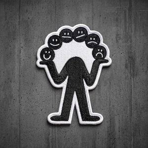 May include: A black and white embroidered patch featuring a stylized figure with no head, holding up an arc of five circular faces. The faces display a range of expressions from a happy smile on the left to a sad frown on the right, all outlined in white.