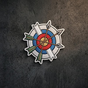May include: An embroidered patch featuring a circular archery target with concentric rings in yellow, red, and blue. Three crossed arrows with green fletching and grey tips are layered over the target, which is framed by a white border.