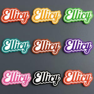 May include: Nine embroidered patches featuring the word Ellicy in a white cursive script with a thick, colored border. The patches come in red, yellow, green, teal, brown, purple, pink, black, and orange, each with a scalloped edge design.