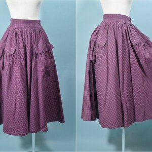 May include: A purple and green plaid skirt with large pockets. The skirt is full and has a gathered waist.