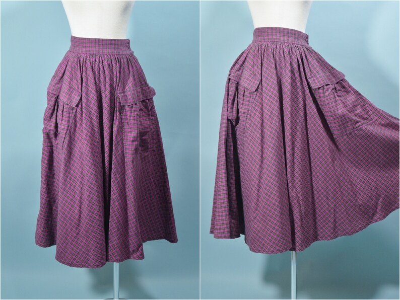 May include: A purple and green plaid skirt with large pockets. The skirt is full and has a gathered waist.