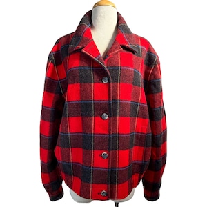 May include: A red, black, and blue plaid jacket with a button-up front and a collar. The jacket is displayed on a mannequin. The plaid pattern is a classic design, and the jacket appears to be made of a warm material.