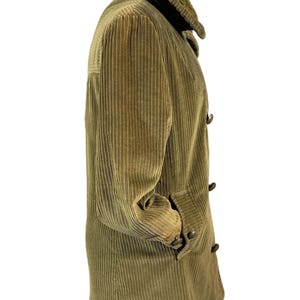 May include: Olive green corduroy coat with a plush collar. The coat features a button-up front, two pockets, and a classic design. The corduroy fabric has vertical ridges. A timeless outerwear piece.