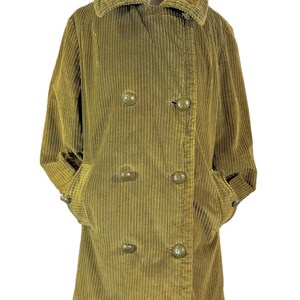 May include: Olive green corduroy coat with a faux fur collar. The double-breasted coat features large, round buttons and pockets. The sleeves are cuffed, and the coat is displayed on a mannequin.