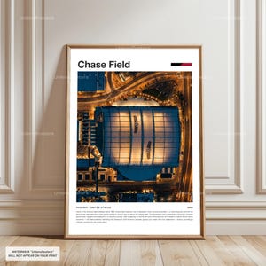 May include: A framed print showing an aerial view of Chase Field in Phoenix, Arizona, at night. The stadium's roof is lit up, with the words "Chase Field" at the top. The print includes the text "PHOENIX - UNITED STATES" and the year "1998".