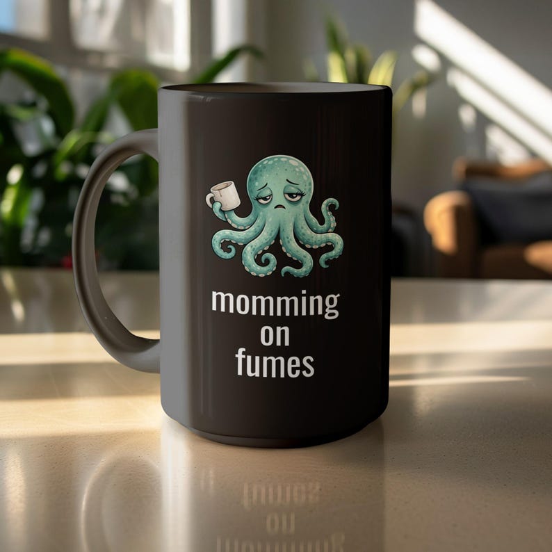 mug with exhausted cartoon octopus with an empty coffee mug featuring the phrase "momming on fumes".