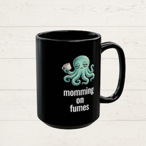 mug with exhausted cartoon octopus with an empty coffee mug featuring the phrase "momming on fumes".