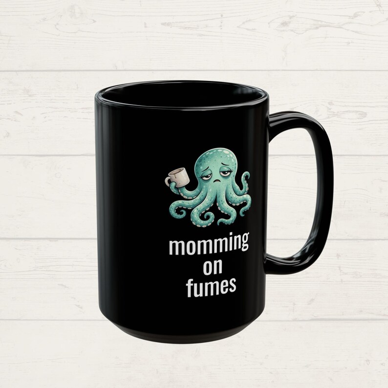 mug with exhausted cartoon octopus with an empty coffee mug featuring the phrase "momming on fumes".