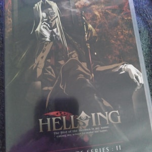 May include: DVD of the anime series Hellsing: Ultimate Series II. The cover art features a character with long white hair, a monocle, and a dark suit. The title is in large white letters with the quote "The Bird of the Hermes is my name, eating my wings to make me tame."