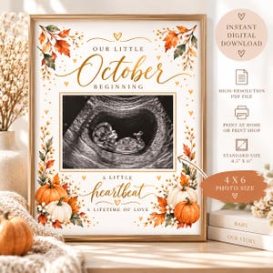 Könnte beinhalten: Ein goldgerahmtes Schild mit herbstlichen Illustrationen von orangefarbenen und weißen Kürbissen und Herbstblättern. Der Text lautet Our Little October Beginning und A Little Heartbeat A Lifetime Of Love, mit einem zentralen Platz für ein 10x15 cm Ultraschallbild.