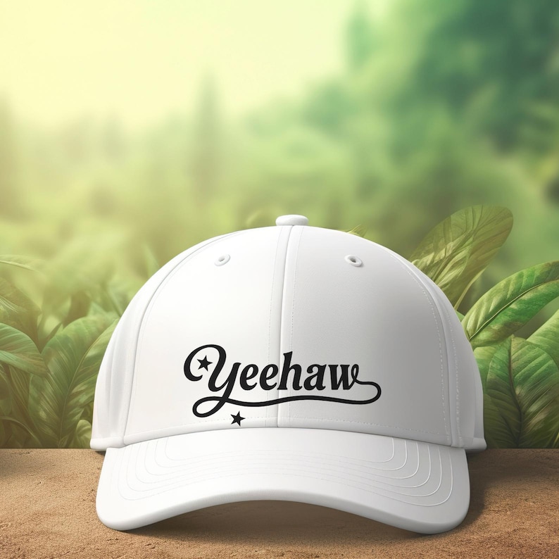 K&ouml;nnte beinhalten: Eine wei&szlig;e Baseballkappe mit dem Wort "Yeehaw" in schwarzer Schrift. Die Kappe hat einen gebogenen Schirm und einen Knopf oben. Der Hintergrund ist ein verschwommenes Bild von gr&uuml;nem Laub.