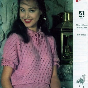 May include: A pink knitted sweater with a lace pattern and short sleeves. The sweater has a tie at the neck. The pattern number is 3459 Emu 4 ply. The size range is 76 to 102 cm.