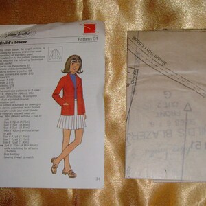 Może przedstawiać: Wzór szycia na dziecięcą marynarkę. Wzór jest oznaczony jako "Child's Blazer" i "Pattern 51". Wzór zawiera instrukcje dotyczące szycia marynarki, w tym wymagania dotyczące tkaniny, akcesoriów i instrukcje szycia.