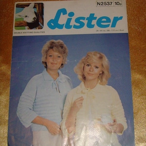 Könnte beinhalten: Ein Strickmusterheft mit blauem Hintergrund und dem Wort "Lister" in großen blauen Buchstaben. Das Cover zeigt zwei Frauen, die gestrickte Pullover tragen, einen in hellblau und einen in weiß. Der Text "Double Knitting Qualities" befindet sich oben auf dem Cover, und der Text "N2537 10p" befindet sich oben rechts. Der Text "34-44 ins. (86-112 cm.) Bust" befindet sich unten rechts.