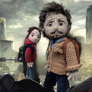 May include: Two crocheted figures, one adult and one child, stand in a post-apocalyptic setting. The adult figure is wearing a brown jacket, blue jeans, and a watch. The child figure is wearing a red jacket and blue jeans. Both figures are carrying backpacks.