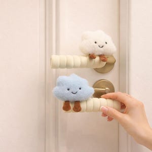 May include: A set of three ceramic mugs with a speckled, matte finish. The mugs are in shades of cream, light grey, and dark grey. Each mug has a simple, minimalist design, ideal for coffee or tea.