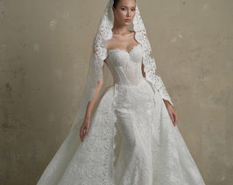 Vestido de noiva sereia romântico com corpete de renda, sobressaia e véu de renda combinando.
