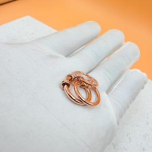 Anillo de plata de ley bicolor con múltiples bandas y diseño de eslabones conectados.