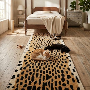 Op de afbeelding: Een slaapkamer met een tapijt met luipaardprint waarop drie katten liggen. Het tapijt is bruin met zwarte vlekken. Op de achtergrond een hemelbed van hout, een nachtkastje, een dressoir en een plant in een pot.