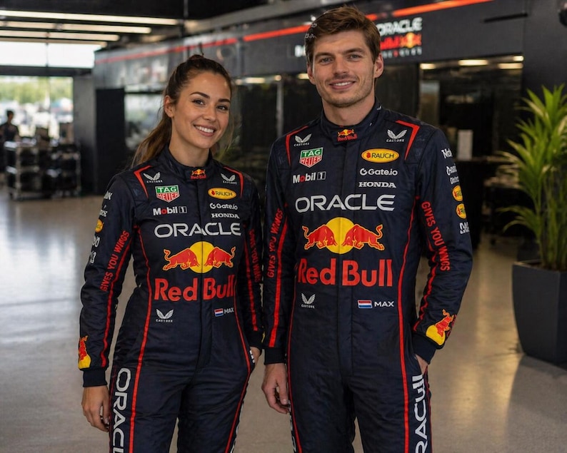 Op de afbeelding: Twee personen in bijpassende donkerblauwe Oracle Red Bull Racing team-raceoveralls. De pakken zijn voorzien van rode en gele branding, waaronder het Red Bull-logo, de tekst Oracle en diverse sponsorlogo's zoals TAG Heuer, Mobil 1 en Honda.