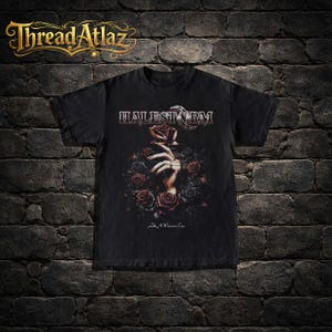 May include: Black t-shirt featuring the band name "HALESTORM" in silver lettering above a graphic of a hand holding a red rose surrounded by red and black roses. The text "Like A Woman Can" is below the graphic.