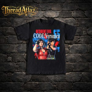 May include: Black t-shirt with the text "RESIDENT EVIL CODE: Veronica" and a graphic of two characters. The CAPCOM logo is also present. The Thread Atlaz logo is at the top.