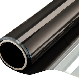 Puede incluir: Un rollo de película para ventanas de color gris oscuro. La película está enrollada firmemente, revelando una superficie brillante que refleja la luz. El núcleo del rollo es de un color más claro, proporcionando contraste con la película oscura.