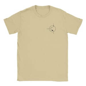 Peut inclure: Un t-shirt beige à manches courtes avec un petit symbole de transistor noir sur le haut de la poitrine gauche. Le symbole est un graphique stylisé utilisé en électronique pour représenter un transistor, un dispositif semi-conducteur.