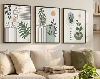 May include: Three framed botanical art prints with black frames. Each print features abstract designs of leaves, arches, and sun-like circles in shades of green, beige, and black. The artwork is displayed above a beige sofa with pillows.