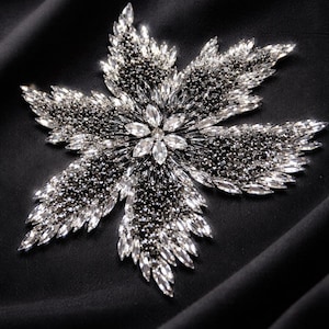 Peut inclure: Une tasse en céramique blanche ornée d'un motif floral coloré. La tasse présente des fleurs roses, violettes et jaunes avec des feuilles vertes. Elle possède une anse simple et incurvée.