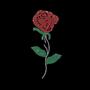 May include: A rose design created with small, reflective red, green, and white rhinestones. The flower head is composed of red stones, the stem and leaves are made of green stones, and a thin white stone line accents the stem on a black background.