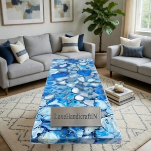 May include: A rectangular coffee table with a mosaic top made of blue and white stones. The table has a silver nameplate that reads "LuxeHandicraftIN". The table is supported by four wooden legs.