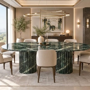 Puede incluir: Una gran mesa de comedor ovalada con una superficie de mármol verde pulido con vetas blancas, sostenida por dos bases cilíndricas con detalles estriados verticales, rodeada de seis sillas tapizadas en tela beige claro con patas de madera oscura.