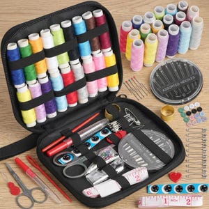 May include: A black zippered sewing kit case containing rows of colorful thread spools, scissors, a seam ripper, a measuring tape, safety pins, buttons, and two circular containers labeled "ASSORTED NEEDLES" with various sewing tools and supplies.