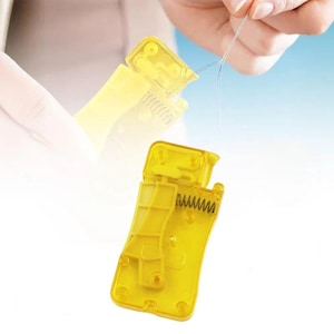 May include: A yellow plastic automatic needle threader featuring a spring-loaded mechanism and a small metal hook. The device is designed to assist in passing a thin thread through the eye of a sewing needle, shown with a needle and thread.