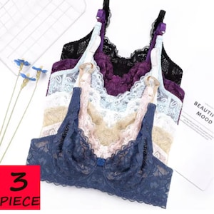 Puede incluir: Un conjunto de tres sujetadores de encaje en varios colores: azul marino, rosa, beige, azul claro, morado y negro. Los sujetadores tienen tirantes ajustables y un diseño de encaje floral. Incluye el texto "3 PIECE".