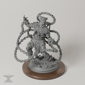 Op de afbeelding: Een grijs, ongeverfd hars miniatuurfiguur van een gehoornd, gespierd mensachtig wezen. Het figuur is omringd door lange, stekelige, kettingachtige aanhangsels die rond het lichaam wervelen en op een ronde voetstuk zijn geplaatst.