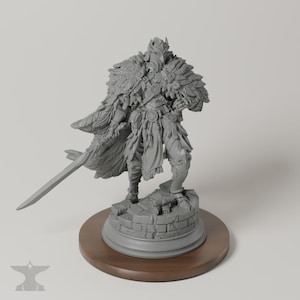 May include: A gray unpainted resin miniature figurine of a warrior wearing a feathered cloak and ornate armor, holding a long sword. The figure stands on a circular stone-textured base with scrolls, mounted on a round wooden display stand.