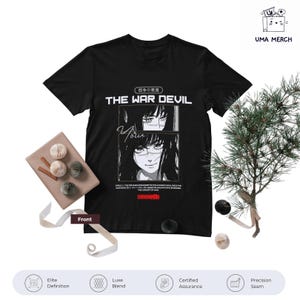 Pode incluir: Camiseta preta com um design gráfico com o texto "THE WAR DEVIL" e caracteres japoneses. O design inclui dois retratos em estilo anime em preto e branco. A camiseta é exibida em uma superfície branca com elementos decorativos.