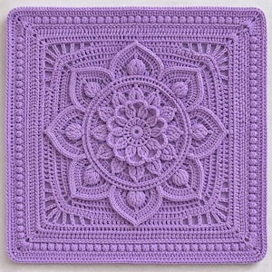 May include: A square, lavender-colored crochet piece featuring a central floral design. The design includes a detailed, raised flower surrounded by stylized petals and a textured border. The piece is crafted with intricate stitch work.