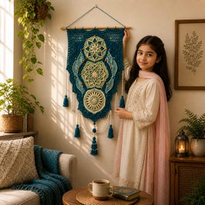 May include: A teal and cream crochet wall hanging with a geometric design. The wall hanging is adorned with wooden beads, tassels, and a wooden rod for hanging. The piece is displayed in a cozy living room setting.