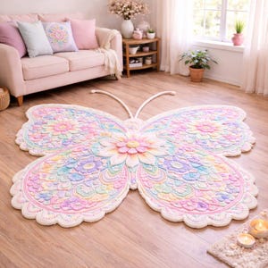 May include: A large, butterfly-shaped rug in pastel shades of pink, yellow, blue, and green. The rug has a detailed floral design in the centre and on the wings, with a scalloped edge. The rug is made of soft material.