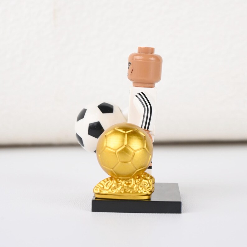 May include: A white ceramic mug with a black handle and the text "But First, Coffee" in a handwritten style. The mug is on a white surface. The mug is approximately 4 inches tall.